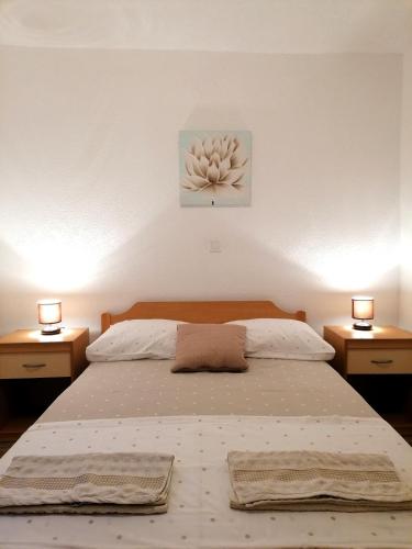 a bedroom with a large bed with two night stands at Apartments Amfora in Gdinj