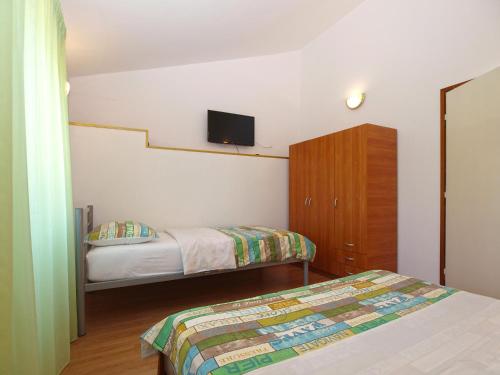 1 dormitorio con 2 camas y TV en la pared en Apartments Klaudio 1318, en Pomer