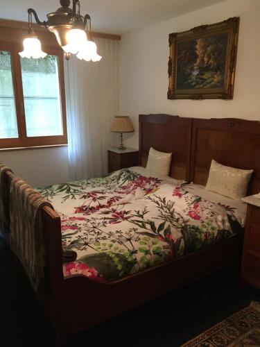 a bedroom with a bed with a floral bedspread at Leimernhof in Thörishaus