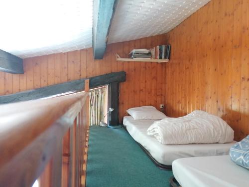 a room with two beds in a wooden wall at Appt 211 Taoures Copropriété SucBlanc in Molines-en-Queyras