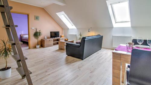 a large living room with a couch and a tv at Boromeum Residence in Hradec Králové