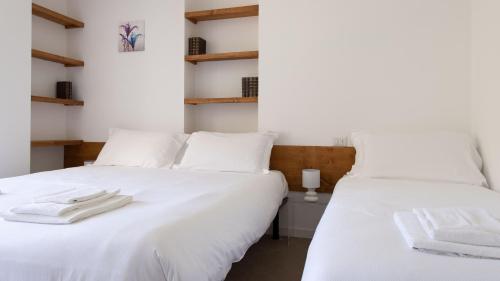 two beds in a room with white sheets at Italianway - Villa Tola in Valdisotto