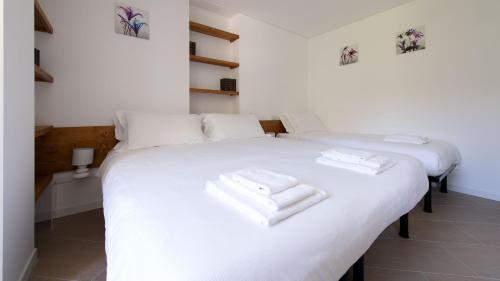 two beds in a room with white towels on them at Italianway - Villa Tola in Valdisotto