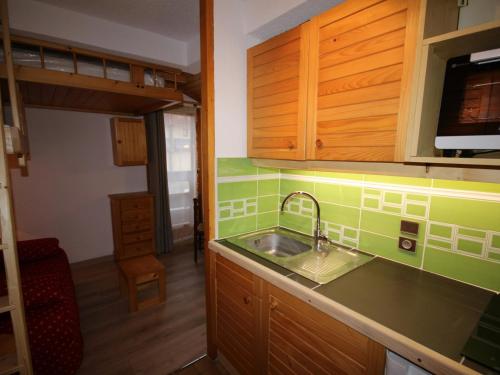 una cucina con lavandino e armadi in legno di Studio Les Saisies, 1 pièce, 2 personnes - FR-1-293-185 a Les Saisies