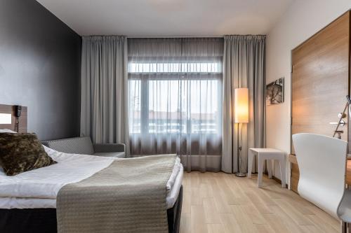 a hotel room with a bed and a window at Holiday Club Vierumäki in Vierumäki