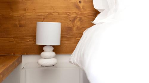 a white lamp sitting on a table next to a bed at Italianway - Villa Tola in Valdisotto