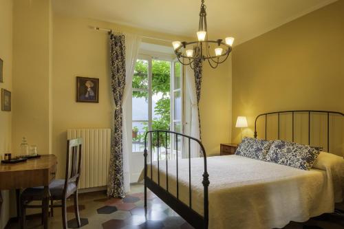 een slaapkamer met een bed, een bureau en een raam bij B&B Villa le Ortensie in Faggeto Lario 