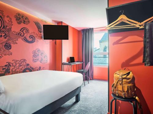 une chambre d'hôtel avec un lit et un sac à dos dans l'établissement Ibis Styles Paris Gare de l'Est Magenta, à Paris