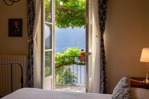 a bedroom with a door open to a balcony at B&B Villa le Ortensie in Faggeto Lario 