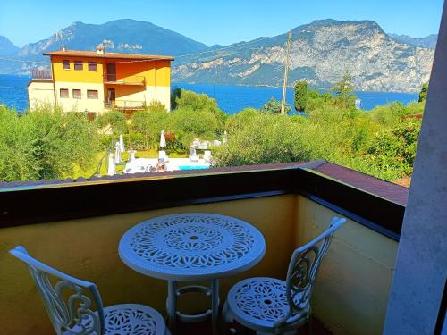 a table and two chairs on a balcony with a view at Hotel Villa Isabella in Brenzone sul Garda