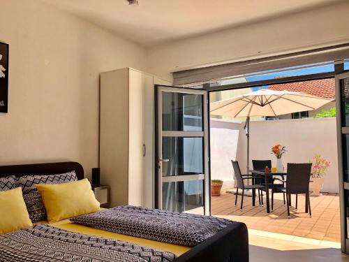 a bedroom with a bed and a patio with an umbrella at Dream Apartments in Mostar