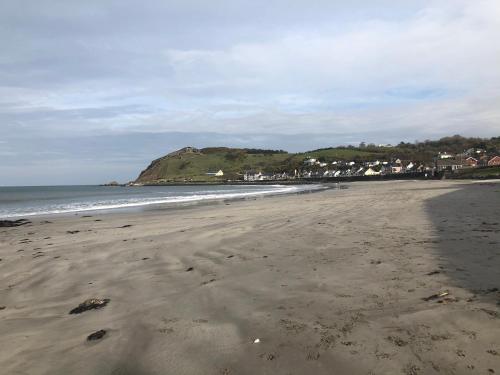 a beach with footprints in the sand and the ocean at Cairnview Bed and Breakfast in Larne