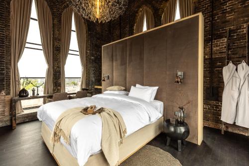 een slaapkamer met een groot bed en een groot raam bij The Clock Tower in Weesp