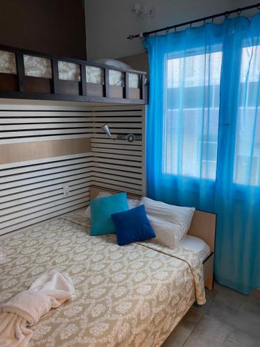 a bedroom with a bed with blue curtains at Amaryllis Hotel in Rhodes Town