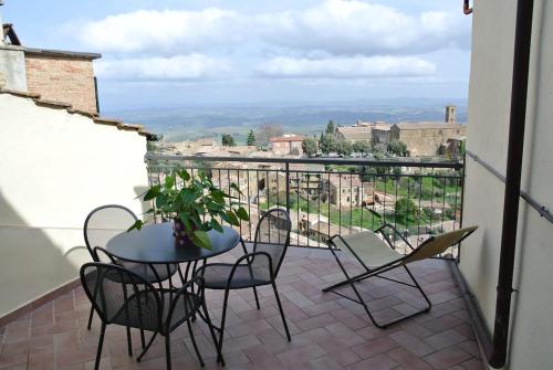 a patio with a table and chairs on a balcony at Historic Center Apartment with Private Garage in Montalcino
