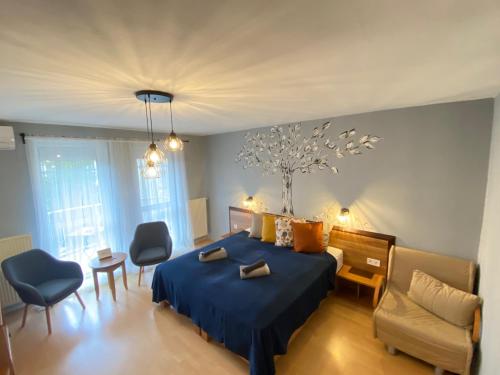 エゲルにあるTündérpart Apartmentのベッドルーム(青いベッド1台、ソファ、椅子付)