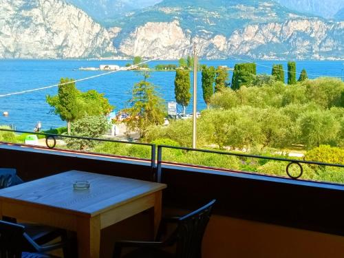 a room with a table and a view of the water at Hotel Villa Isabella in Brenzone sul Garda