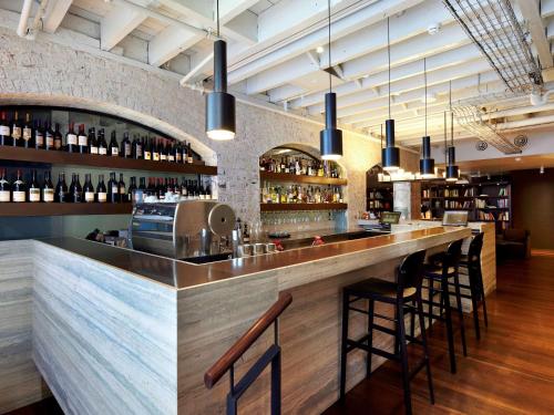 a kitchen with a bar and a wine cellar at Harbour Rocks Hotel Sydney – MGallery by Sofitel in Sydney