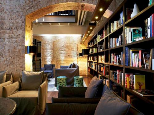 a living room filled with lots of books and a fireplace at Harbour Rocks Hotel Sydney – MGallery by Sofitel in Sydney