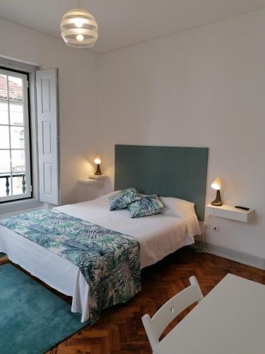 a bedroom with a large bed and two chairs at Hostel Rossio Alcobaça in Alcobaça