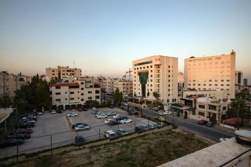 a city with cars parked in a parking lot at Bristol Hotel in Amman