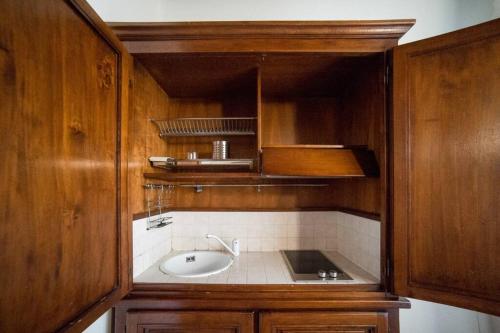La salle de bains est pourvue d'un lavabo et d'une armoire en bois. dans l'établissement HBHALL Navigli 2 Apartment, à Milan
