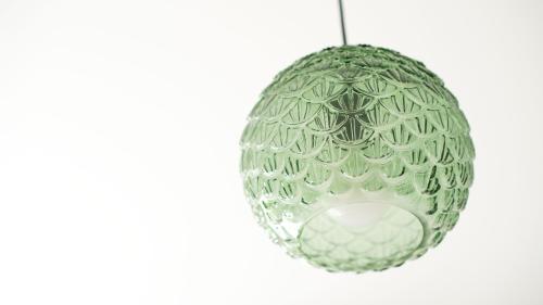 a green glass ball ornament on a white background at Italianway - Villa Tola in Valdisotto