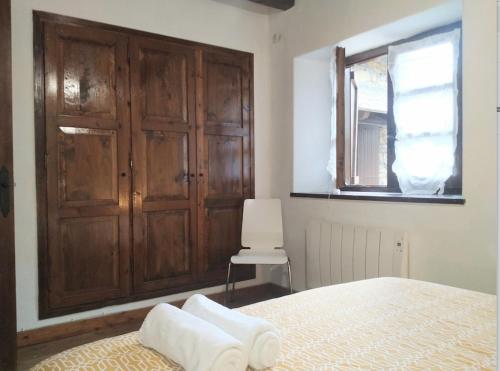 a bedroom with a bed and a window and a chair at Apartamento Linsoles Forcau in Benasque