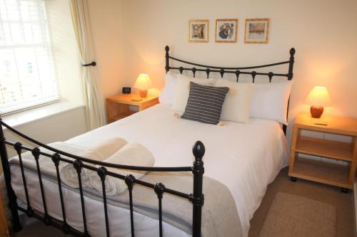 a bedroom with a black and white bed with two lamps at 131 on Atholl in Pitlochry