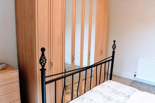 um quarto com uma cama e um armário de madeira em Cosy and Modern Apartment in Central Edinburgh em Edimburgo