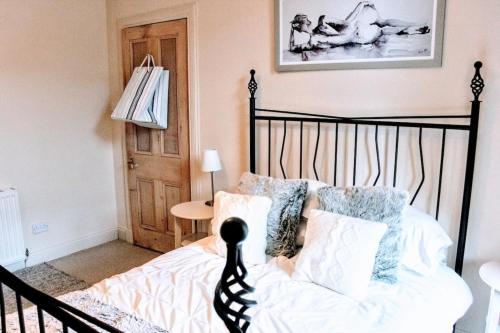 a bedroom with a black and white bed with pillows at Cosy and Modern Apartment in Central Edinburgh in Edinburgh