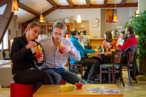 twee mensen aan een tafel met drankjes bij VTF Les Esquirousses in Arvieux