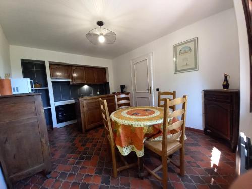 une cuisine avec une table recouverte d'une nappe dans l'établissement LES PINS, au Castellet