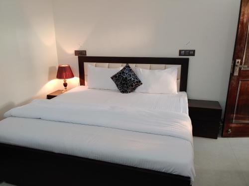 a bedroom with a large bed with white sheets and pillows at Touristen Holiday Home A luxury Villa in Dharamshala