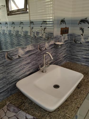 a white sink in a bathroom with birds on the wall at Touristen Holiday Home A luxury Villa in Dharamshala