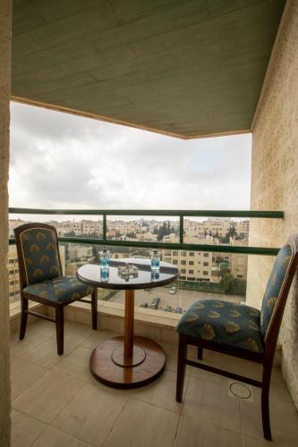 a room with two chairs and a table and a window at Bristol Hotel in Amman