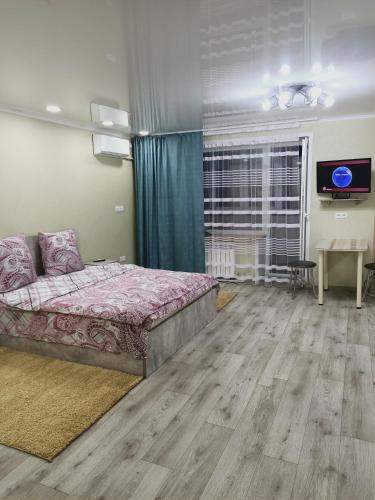 ApartNew in City Centr في أوست - كامينوغورسك: غرفة نوم فيها سرير وتلفزيون