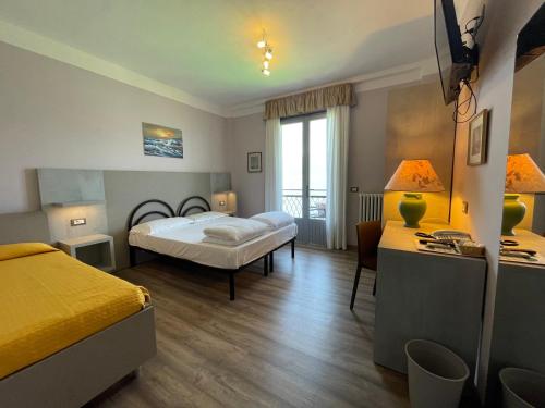 a hotel room with two beds and a window at Hotel Rabay in Brenzone sul Garda