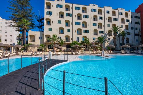 a large swimming pool in front of a large building at Hotel Hopps in Mazara del Vallo