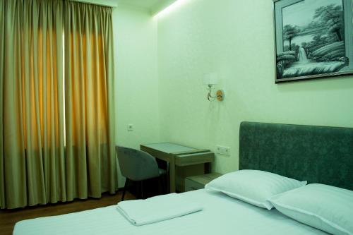 a hotel room with a bed and a desk at Registon Saroy Hotel in Samarkand