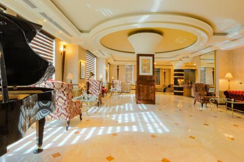 a large lobby with a piano and chairs at Bristol Hotel in Amman