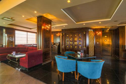 a restaurant with blue chairs and a table and a couch at Bristol Hotel in Amman