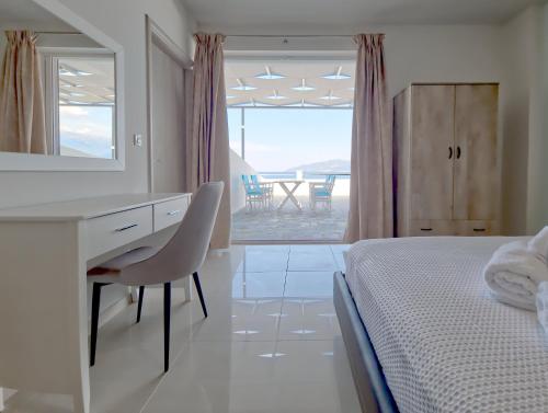 a bedroom with a desk and a bed with a mirror at Epipleon Luxury Suites -105- Δωμάτιο 35τμ με βεράντα 35τμ μπροστά στη θάλασσα in Nafpaktos