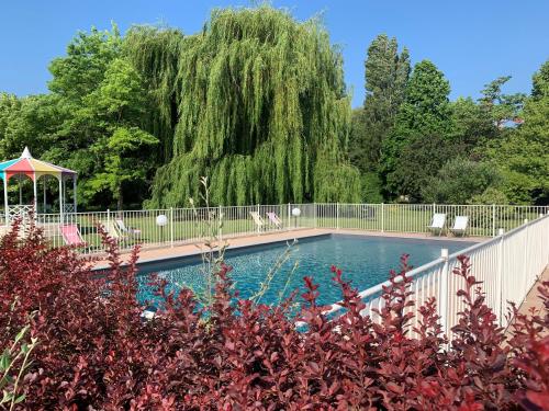 a swimming pool with chairs and a gazebo at greet Hotel Beaune in Beaune