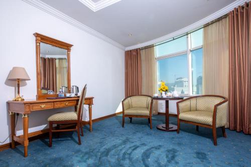 a room with a desk and chairs and a mirror at Bristol Hotel in Amman