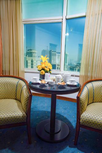 a table in a room with two chairs and a window at Bristol Hotel in Amman