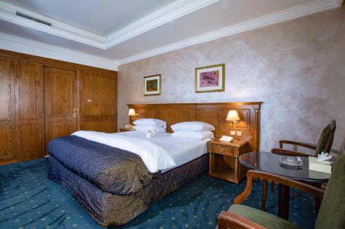 a hotel room with a bed and a desk at Bristol Hotel in Amman