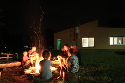 a group of people sitting around a fire at night at Penzion - Apartments Pod Javořicí in Horní Dubenky