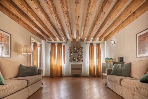 a living room with two couches and a wooden ceiling at Corte Contarina San Marco Apartment R&R in Venice
