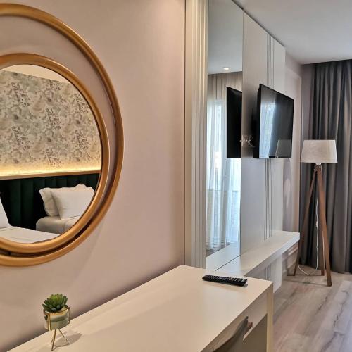 a living room with a mirror and a bed at Iliad Hotel in Durrës